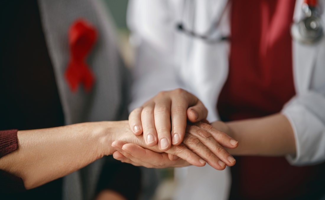 Two people clasping hands in a gesture of support